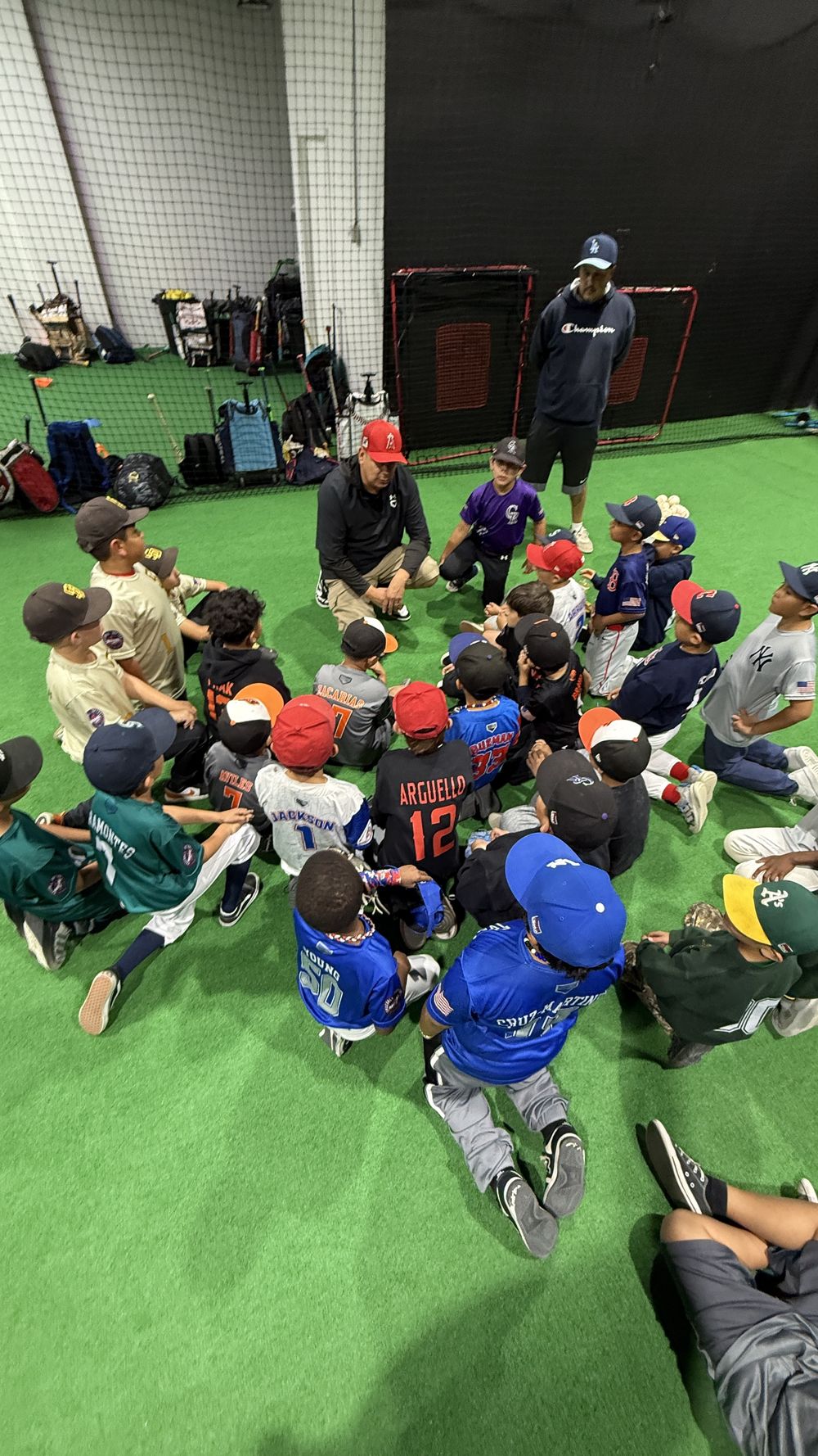 A Launchpad coach working with a group of young players on the turf
